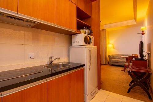 a kitchen with a sink and a microwave at Royale Chulan Kuala Lumpur in Kuala Lumpur