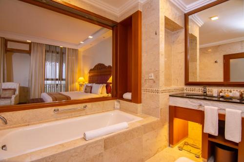 a bathroom with a tub and a large mirror at Royale Chulan Kuala Lumpur in Kuala Lumpur