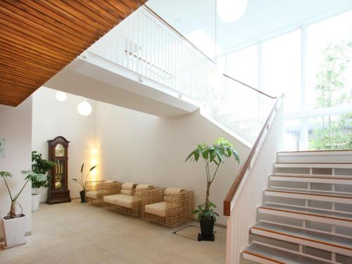 a living room with a couch and stairs at Auberge de South Terrace in Shirahama