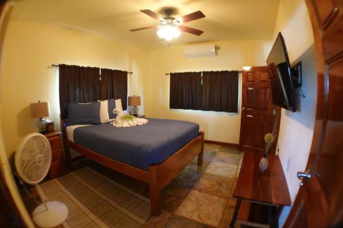 a bedroom with a bed and a ceiling fan at Captain Jak's Rentals in Placencia