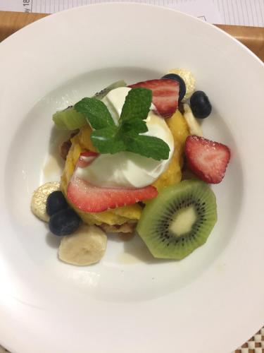 un plato de comida con fruta y nata. en Forgandenny House B&B, en Mudgee