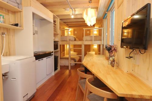 a kitchen and dining room with a long table in a tiny house at JR Mobile Inn Sapporo kotoni in Sapporo