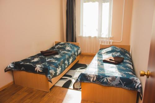 a bedroom with two beds and a window at Hotel Tahar in Almaty