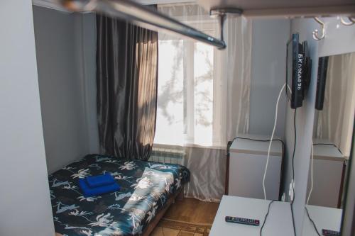 a small bedroom with a bed and a window at Hotel Tahar in Almaty
