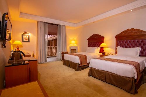 a hotel room with two beds and a television at Royale Chulan Kuala Lumpur in Kuala Lumpur