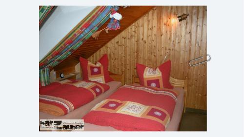 two beds in a room with wooden walls at Ferienwohnung harZauber in Braunlage