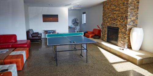a living room with a ping pong table and a fireplace at The Island Accommodation in Phillip Island
