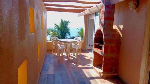 a room with a table and a room with a fireplace at Hotelito Escondido in Manzanillo