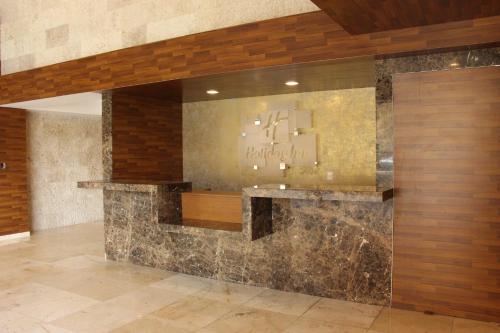 a lobby with a stone wall with a chandelier at Holiday Inn Mexico Santa Fe by IHG in Mexico City