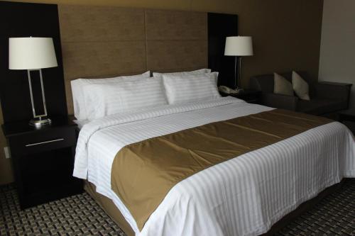 a large bed in a hotel room with two lamps at Holiday Inn Mexico Santa Fe by IHG in Mexico City
