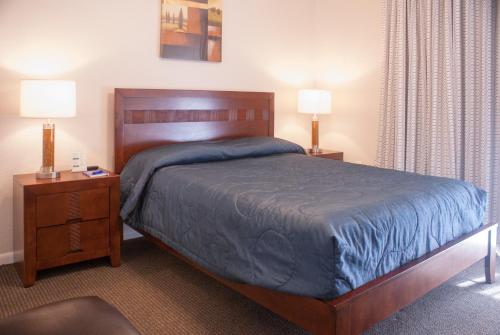 ein Schlafzimmer mit einem großen Bett mit zwei Nachttischen und zwei Lampen in der Unterkunft Grand Lake & Lifetime of Vacations Resorts in Orlando