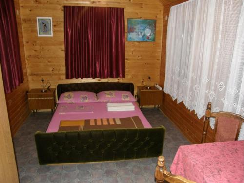 a bedroom with two beds and red curtains at House Ilija Hodak in Seliste Dreznicko