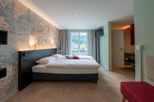 a bedroom with a bed with a map on the wall at Emma's B&B - Self Check-in Hotel in Lungern