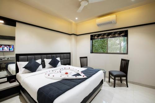 a bedroom with a bed and a desk and chair at MEGH RESIDENCY in Navi Mumbai