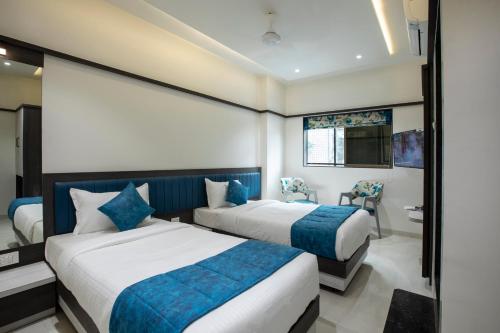 a hotel room with two beds and a bathroom at MEGH RESIDENCY in Navi Mumbai