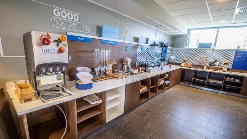 a large kitchen with a counter with food items at Holiday Inn Express & Suites Panama City Beach - Beachfront, an IHG Hotel in Panama City Beach