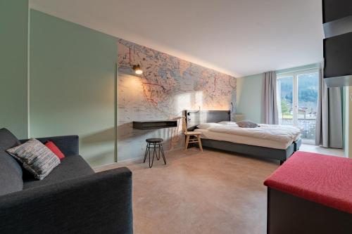 a hotel room with a bed and a couch at Emma's B&B - Self Check-in Hotel in Lungern