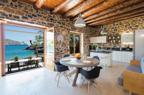 a kitchen and a dining room with a table and chairs at Palio Damnoni Seafront House in Damnoni