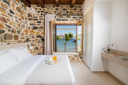 sypialnia z łóżkiem i widokiem na ocean w obiekcie Palio Damnoni Seafront House w mieście Damnoni