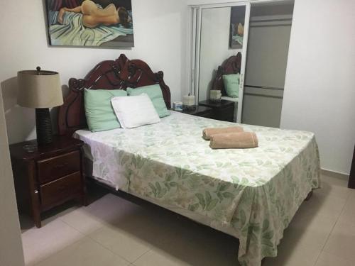 Un dormitorio con una cama con una toalla. en ARCOIRIS SHARE APARTMENT BAVARO PUNTA CANA, en Punta Cana