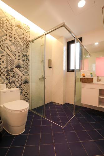 a bathroom with a toilet and a glass shower at Shi Guang Sea View in Magong
