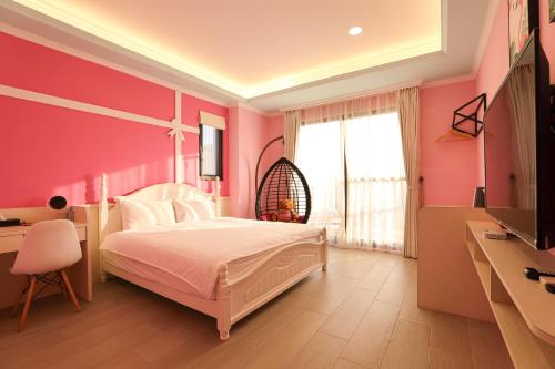 a bedroom with a white bed and a pink wall at Shi Guang Sea View in Magong