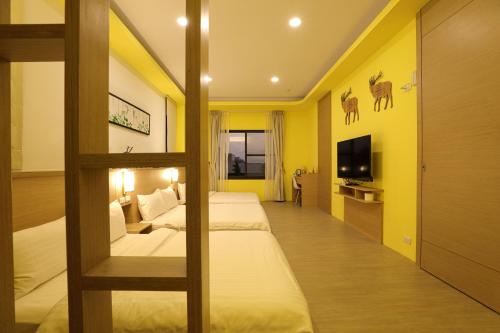 a hotel room with two beds and a tv at Shi Guang Sea View in Magong