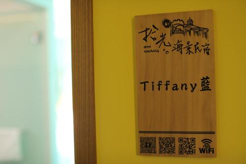 a wooden sign on a wall with writing on it at Shi Guang Sea View in Magong
