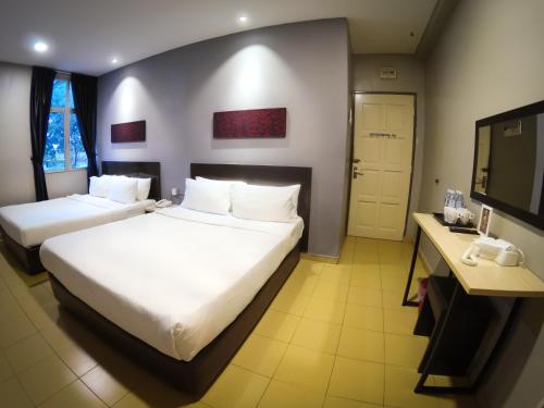 JV Hotel @ Bandar Tasek Mutiara tesisinde bir odada yatak veya yataklar