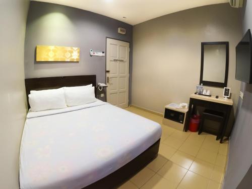 Un pat sau paturi într-o cameră la JV Hotel @ Bandar Tasek Mutiara