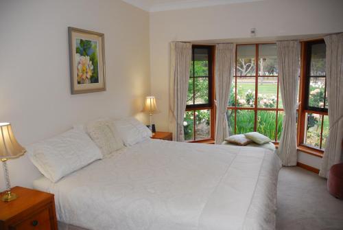 a bedroom with a large white bed and windows at Gaerwood B&B in Keith