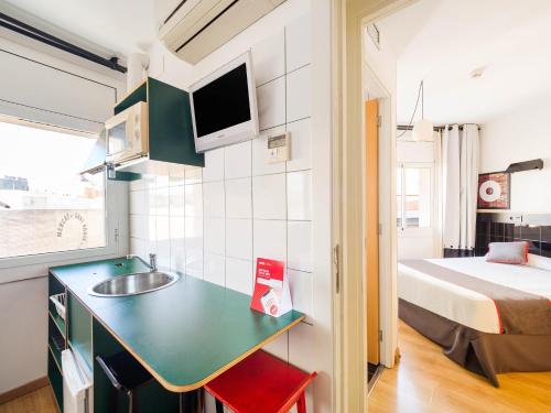 a small kitchen with a sink and a bed in a room at Hostal Athenas in Sant Adria de Besos