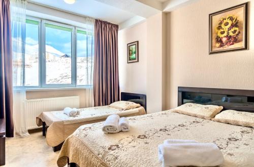 een hotelkamer met 2 bedden en een raam bij 2-room Apartment NFT Gudauri Penta 503 in Goedaoeri