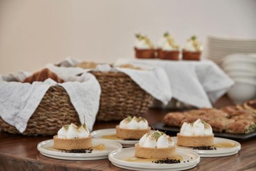 un tavolo con quattro dolci su un piatto di CYCLADES - Semi Based Apartment with Indoor Garden - Part Of White Dunes Luxury Boutique Hotel a Santa Maria