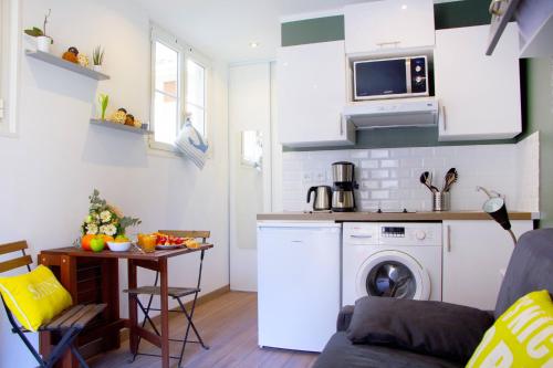 uma cozinha e sala de estar com máquina de lavar e secar roupa em LE REFUGE avec terrasse et jardin, en plein centre-ville, gare 5 minutes à pieds em Nice