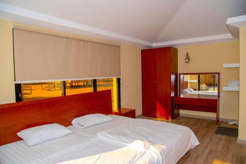 a bedroom with a large white bed with a window at Arabian Oryx Camp in Shāhiq