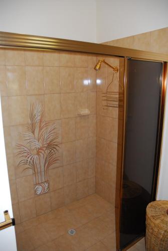 a shower with a glass door with a plant painted on it at Gaerwood B&B in Keith