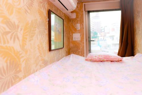 a small bedroom with a bed and a window at Tokyo Guest House 2020 in Tokyo