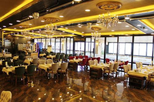 锡瓦斯Savona Otel Sivas的有桌椅和吊灯的餐厅
