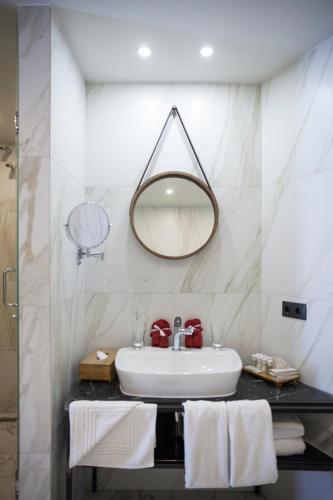 a bathroom with a sink and a mirror and towels at Shota @ Rustaveli Boutique Hotel in Tbilisi City
