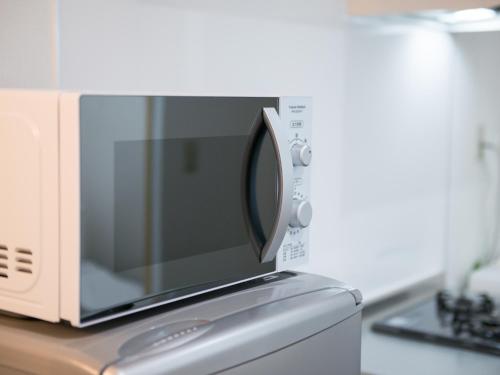 a microwave oven sitting on top of a kitchen counter at Maruka石垣島 in Ishigaki Island