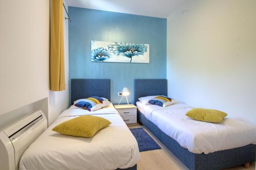 two beds in a room with blue walls at Luxury villa Medulin with pool near the beach , sea view, extra pool heating available in Medulin