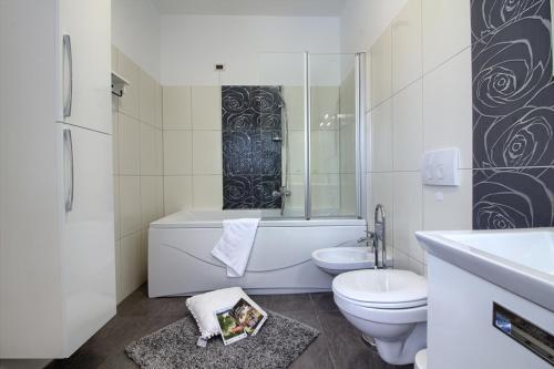 W łazience znajduje się toaleta, wanna i umywalka. w obiekcie Luxury villa Medulin with pool near the beach , sea view, extra pool heating available w Medulinie