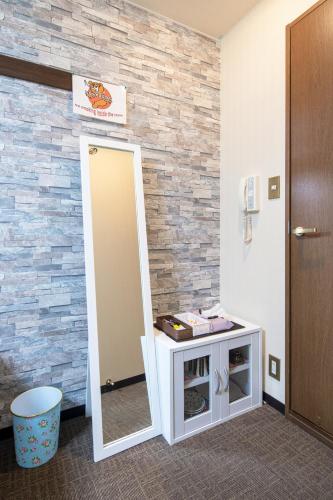 a mirror in a room with a brick wall at Cozy house 307 free wifi a rented electric bicycle in Kyoto