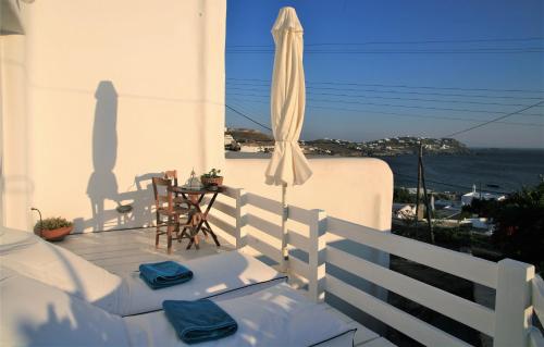 a patio with an umbrella and a table and chairs at Mykonos Moussa in Agios Ioannis Mykonos
