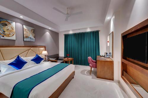 a hotel room with a bed and a television at Click Hotel Aurangabad in Aurangabad