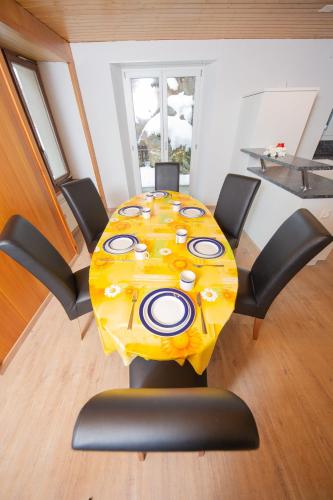 a table in a room with a yellow table cloth at Haus Pickelschmiede in Saas-Grund