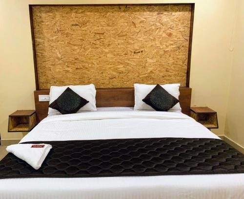 ein Schlafzimmer mit einem großen Bett mit einem großen Kopfteil in der Unterkunft Hotel Annai Bay in Velankanni
