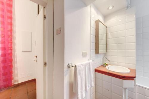 a white bathroom with a sink and a mirror at Nova Domizia in Rome