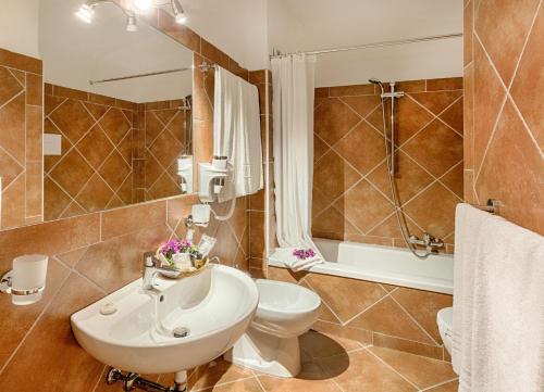 a bathroom with a sink and a toilet and a shower at Colonna Hotel Du Golf in Marina di Portisco